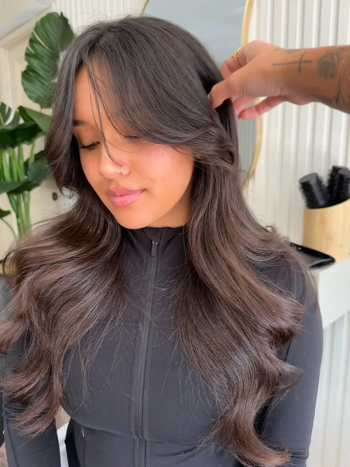 Bouncy brunette blowout with face-framing layers