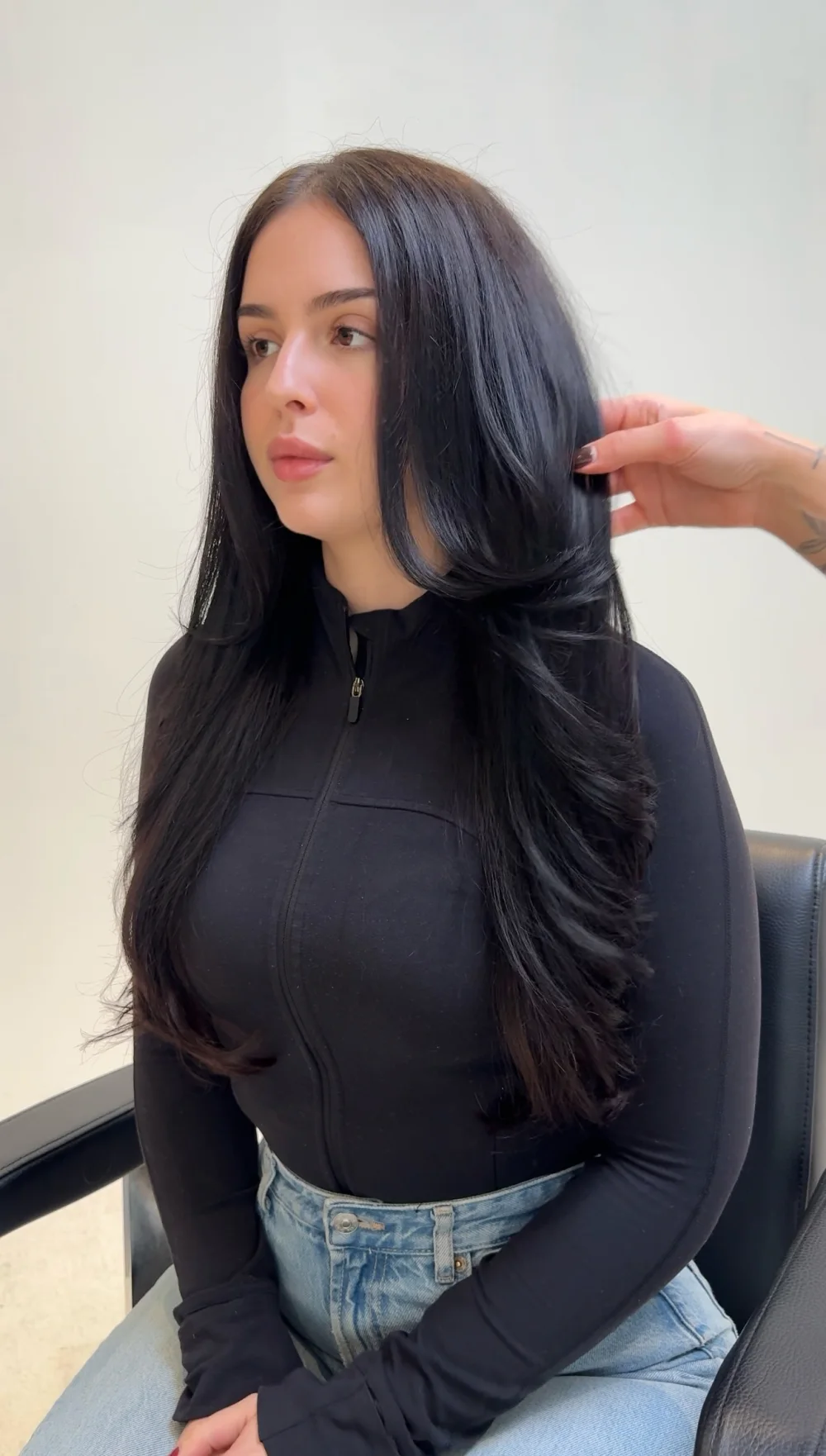 Long, glossy black hair with soft face-framing layers, in the studio chair
